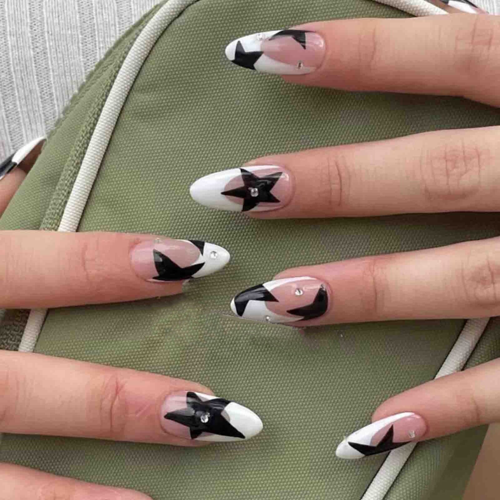 Короткие миндальные ногти Y2K нажимайте на ногте с черными пентаксическими звездами.